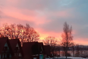 wschód słońca nad domkami  w schronisku, w tle Jezioro Żywieckie